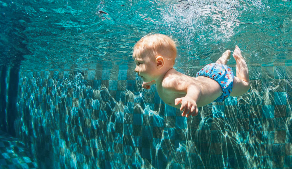 bebê mergulhando na piscina